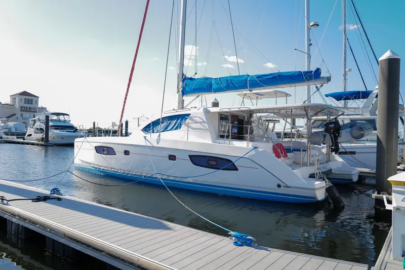The Image of 2012 Leopard 44 catamaran docked at marina, featuring blue accents and spacious deck. - 0