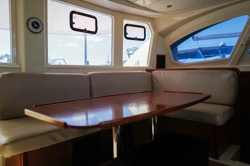 Slide: The Image of Interior of 2012 Leopard 44 yacht with cushioned seating and wooden table. - 14