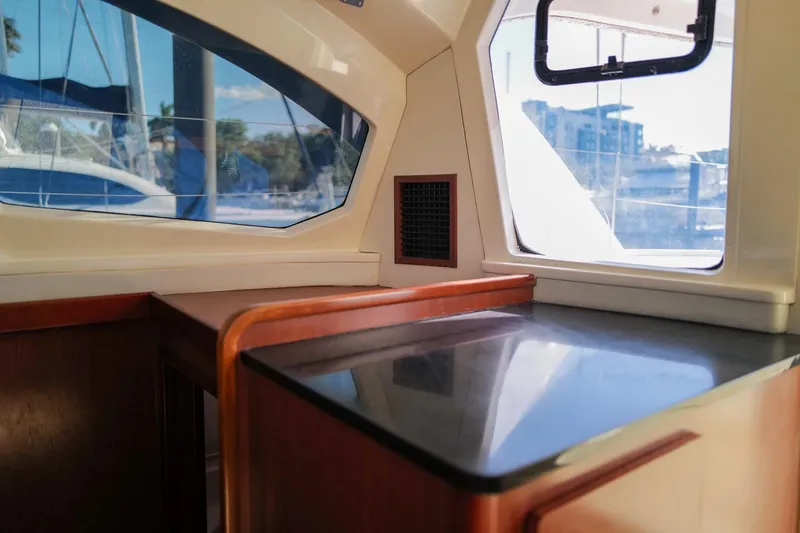 Slide: The Image of Interior view of a 2012 Leopard 44 yacht, featuring sleek wood and window design. - 16