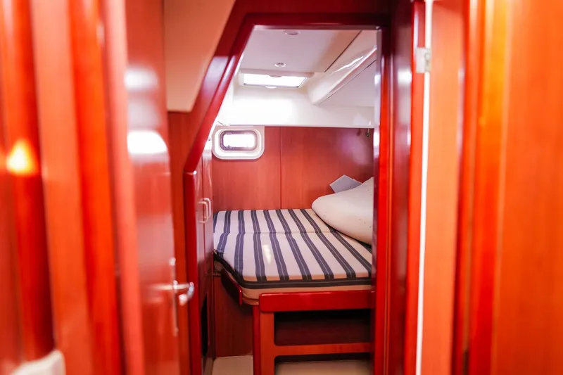 Slide: The Image of Cozy cabin interior of 2012 Leopard 44 yacht with striped bedding and wooden finish. - 17