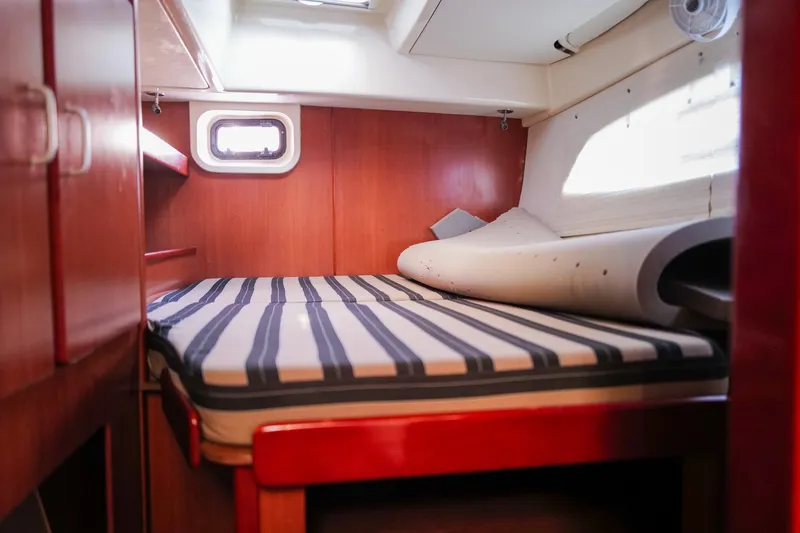 Slide: The Image of Cozy cabin interior of 2012 Leopard 44 yacht with striped bedding and wooden finish. - 18