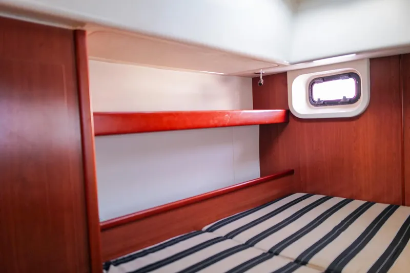 Slide: The Image of Cozy cabin interior of 2012 Leopard 44 yacht with striped bedding and wooden finish. - 19
