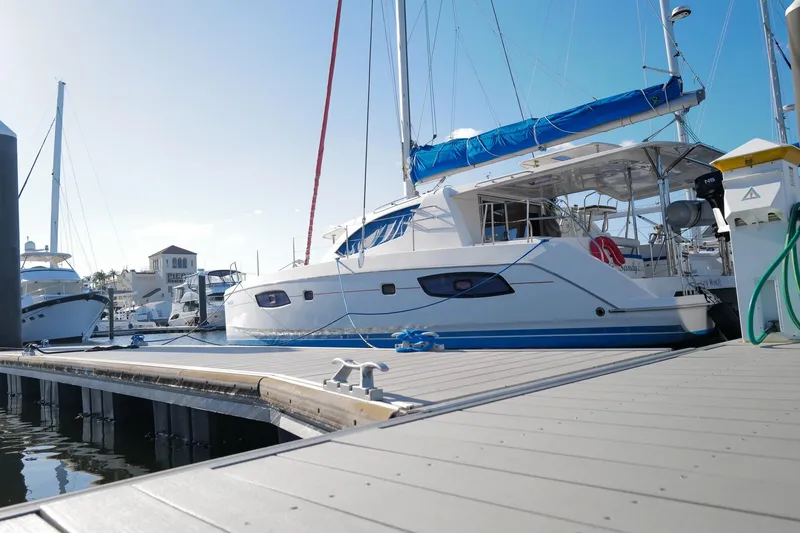 Slide: The Image of 2012 Leopard 44 catamaran docked at marina under clear blue sky. - 2