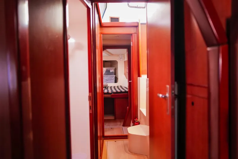 Slide: The Image of Interior view of a 2012 Leopard 44 yacht, featuring polished wood finishes and cozy cabin space. - 20