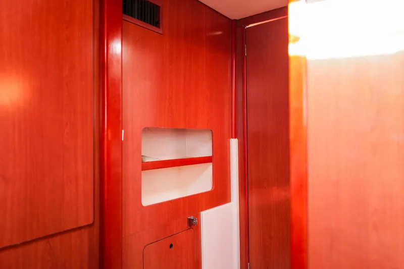 Slide: The Image of Interior of a 2012 Leopard 44 yacht with polished wooden walls and built-in shelving. - 24