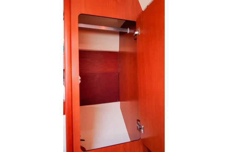 Slide: The Image of Wooden cabinet interior on a 2012 Leopard 44 yacht, featuring a hanging rod. - 25