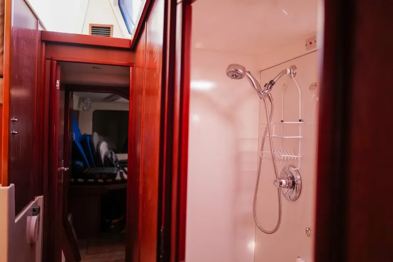 Slide: The Image of Interior of a 2012 Leopard 44 yacht featuring a shower and wooden cabinetry. - 28