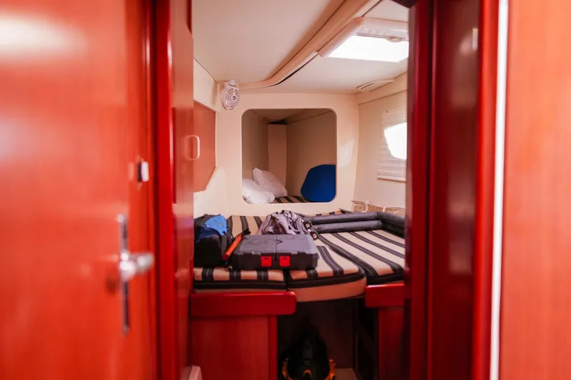 Slide: The Image of Cozy cabin interior of 2012 Leopard 44 yacht with striped bedding and luggage. - 29