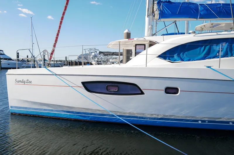 Slide: The Image of 2012 Leopard 44 catamaran "Sandy Lee" docked at marina with blue accents. - 3