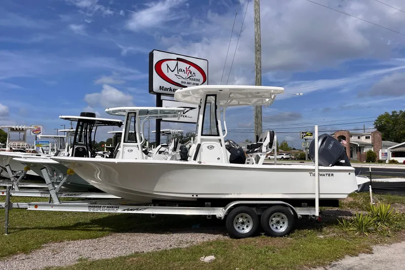 The Image of 2026 Tidewater 2210 Carolina Bay boat on trailer at dealership under blue sky. - 0