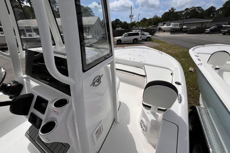 Slide: The Image of 2026 Tidewater 2210 Carolina Bay boat interior with seating and console, parked outdoors. - 7