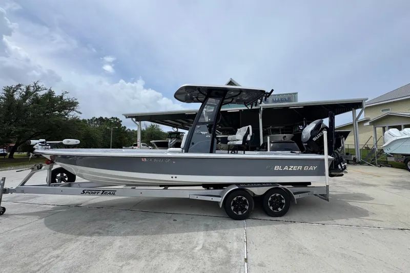 The Image of 2023 Blazer 2550 GTS boat on trailer, parked outdoors under cloudy sky. - 1