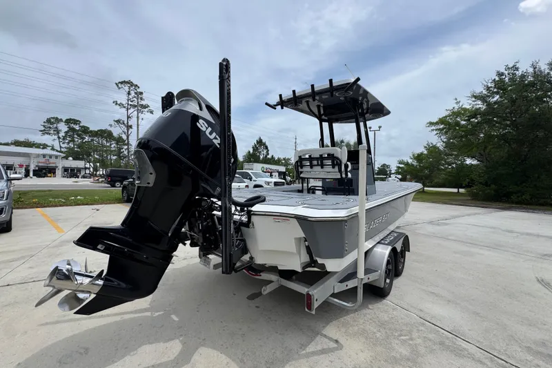 Slide: The Image of 2023 Blazer 2550 GTS boat with Suzuki outboard motor on a trailer in a parking lot. - 12