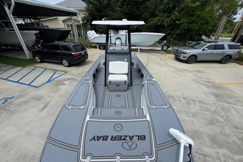 Slide: The Image of 2023 Blazer 2550 GTS boat in parking lot, showcasing sleek design and spacious deck. - 21