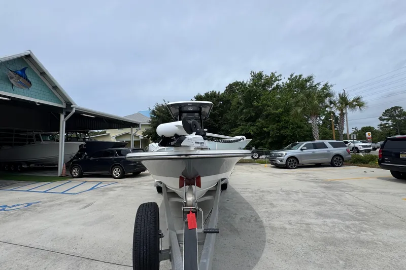 Slide: The Image of 2023 Blazer 2550 GTS boat on trailer in parking lot, surrounded by vehicles and trees. - 5