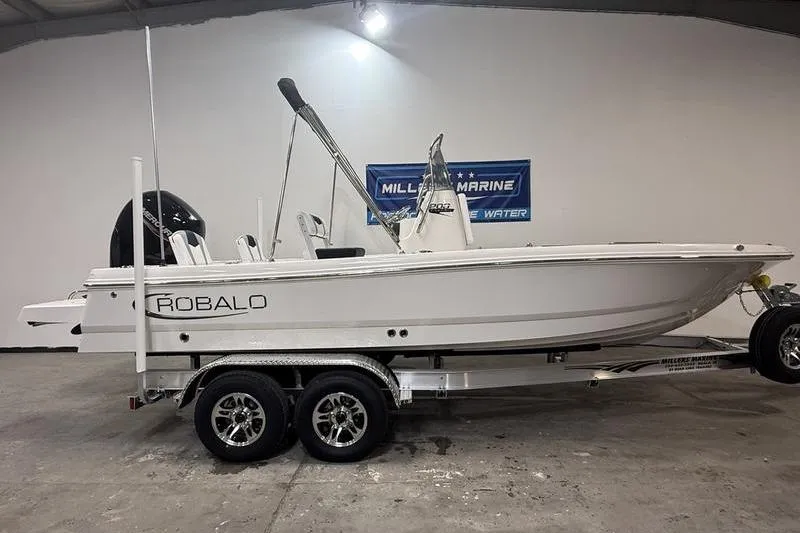 The Image of 2026 Robalo 206 Cayman boat on trailer in showroom. - 0
