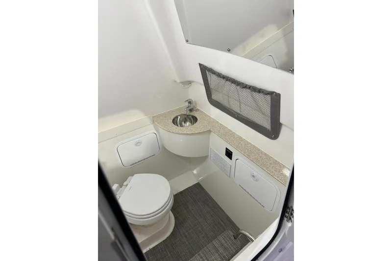 Slide: The Image of 2025 Regulator 28 boat interior bathroom with sink, toilet, and storage compartments. - 14