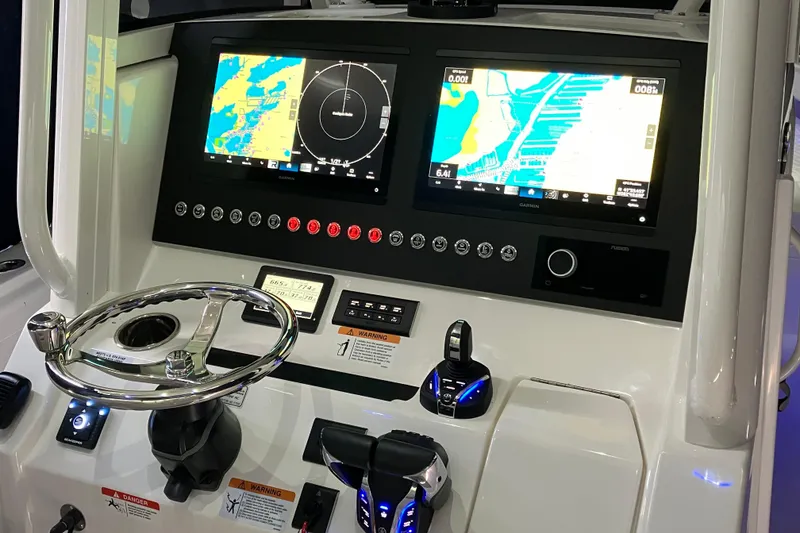Slide: The Image of 2025 Regulator 28 boat dashboard with dual navigation screens and steering wheel. - 6