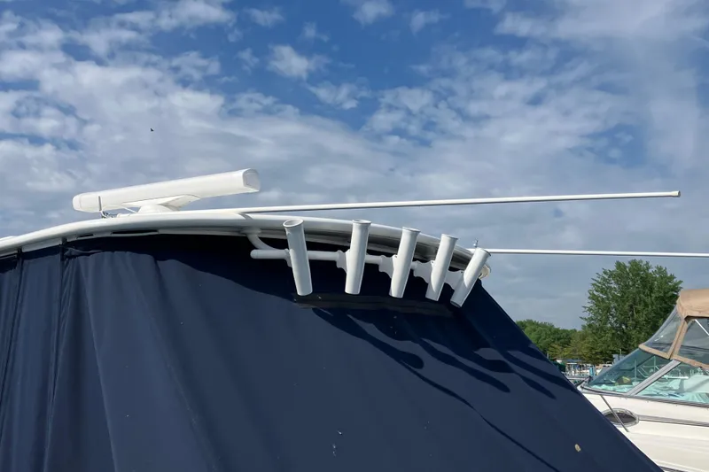 Slide: The Image of 2025 Regulator 28 boat with rod holders and radar, under a clear blue sky. - 13