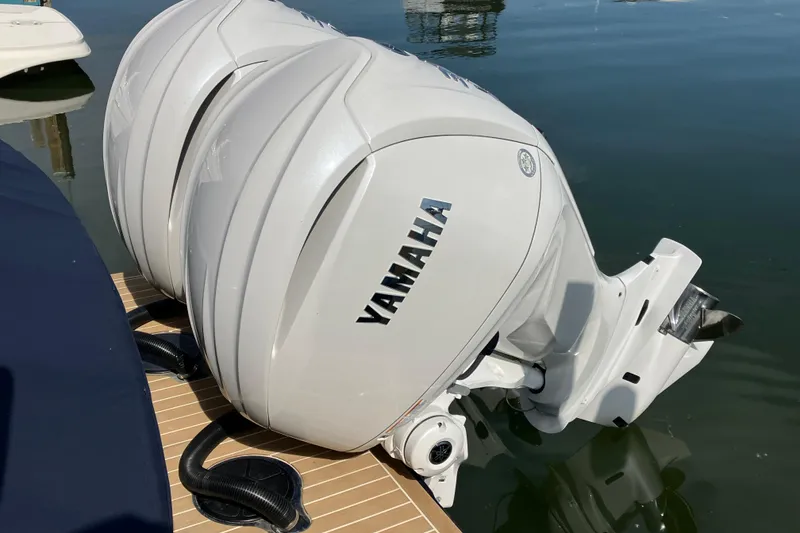 Slide: The Image of Twin Yamaha outboard engines on a 2025 Regulator 28 boat, docked on calm water. - 2