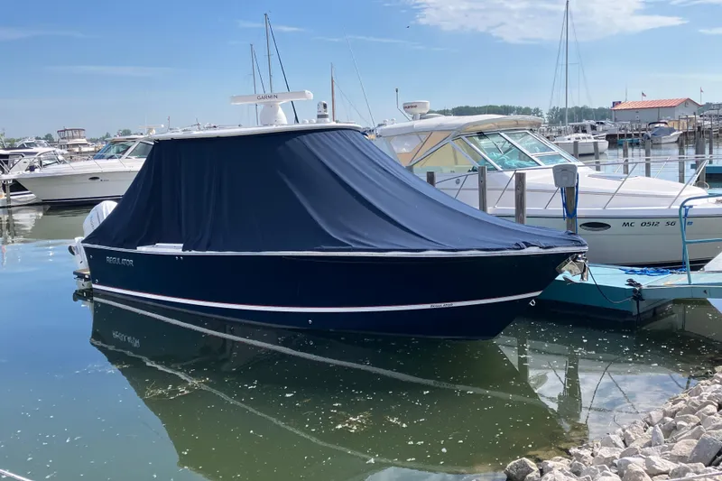 The Image of 2025 Regulator 28 boat with cover docked in a marina. - 0