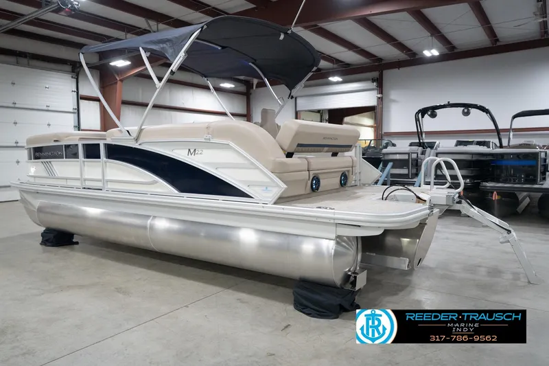 Slide: The Image of 2026 Bennington 22 ML pontoon boat in showroom with canopy and ladder. - 10