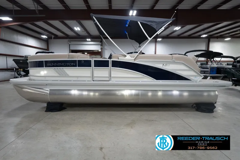 Slide: The Image of 2026 Bennington 22 ML pontoon boat in indoor showroom setting. - 12