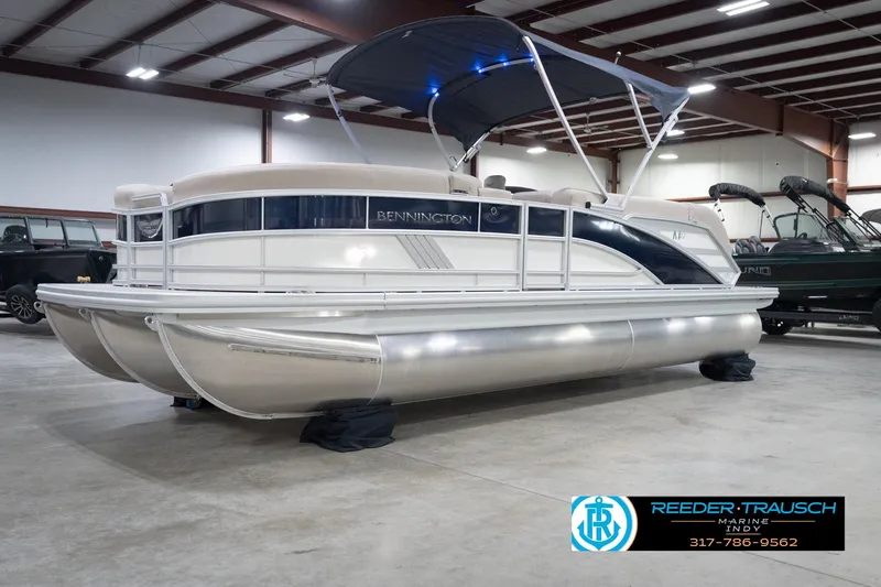 Slide: The Image of 2026 Bennington 22 ML pontoon boat in indoor showroom with canopy. - 2