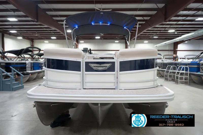 Slide: The Image of 2026 Bennington 22 ML pontoon boat in showroom, featuring sleek design and modern amenities. - 4