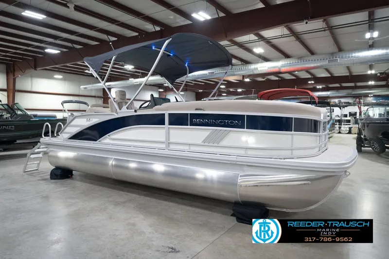 Slide: The Image of 2026 Bennington 22 ML pontoon boat in showroom with canopy and sleek design. - 5