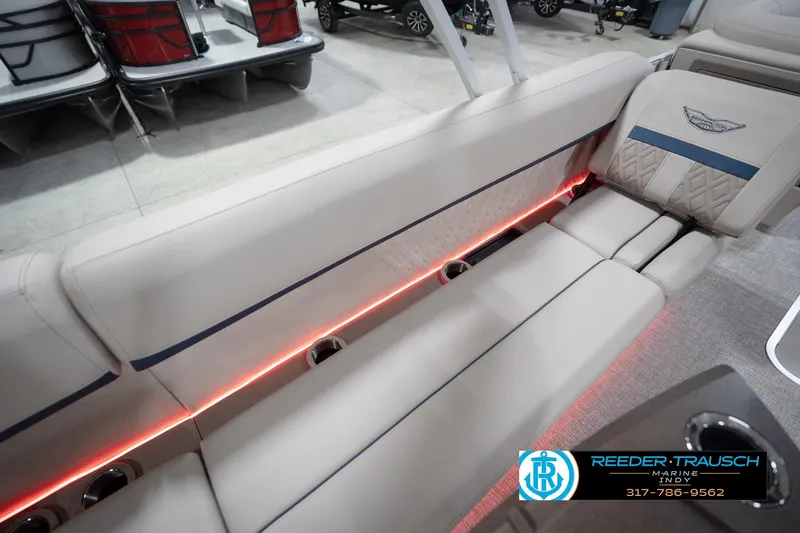 Slide: The Image of 2026 Bennington 22 ML boat interior with beige seating and red LED lighting. - 56