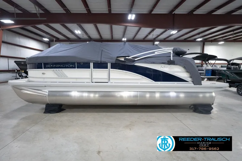 Slide: The Image of 2026 Bennington 22 ML pontoon boat in indoor showroom, covered and ready for sale. - 65