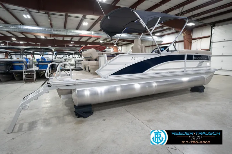 Slide: The Image of 2026 Bennington 22 ML pontoon boat in showroom with canopy and seating. - 8
