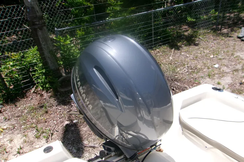 Slide: The Image of Outboard motor on 2022 Key West 1720 Center Console boat, parked near a fence. - 7