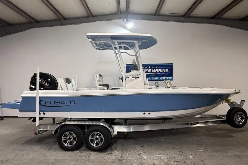 The Image of 2026 Robalo 226 Cayman boat on trailer in indoor showroom. - 0
