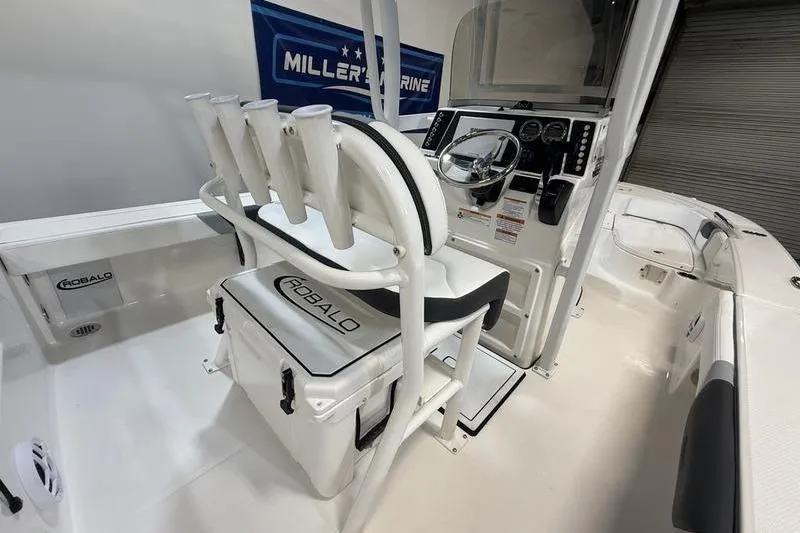 Slide: The Image of 2026 Robalo 226 Cayman boat interior with helm, seating, and rod holders. - 13