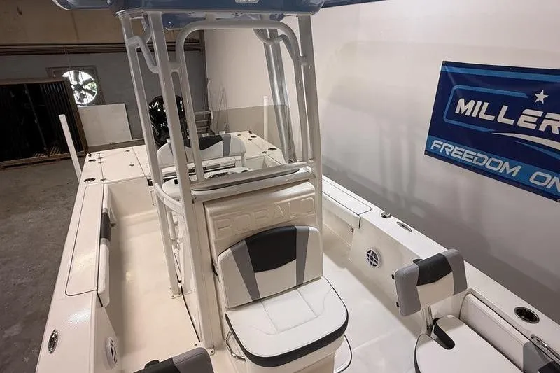 Slide: The Image of 2026 Robalo 226 Cayman boat interior with seating and console in showroom. - 17