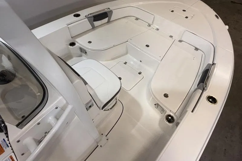 Slide: The Image of 2026 Robalo 226 Cayman boat interior with white seating and storage compartments. - 19