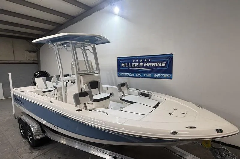 Slide: The Image of 2026 Robalo 226 Cayman boat displayed indoors at Miller's Marine showroom. - 2