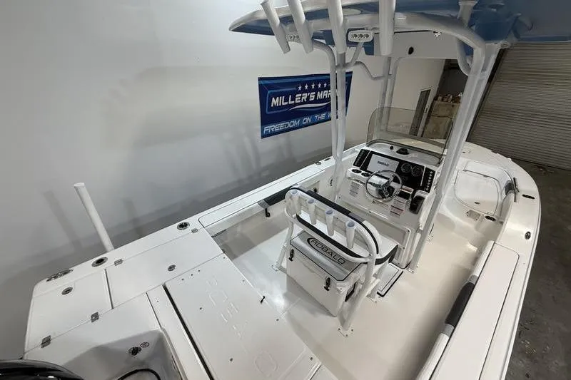 Slide: The Image of 2026 Robalo 226 Cayman boat interior with console and seating, displayed indoors. - 9