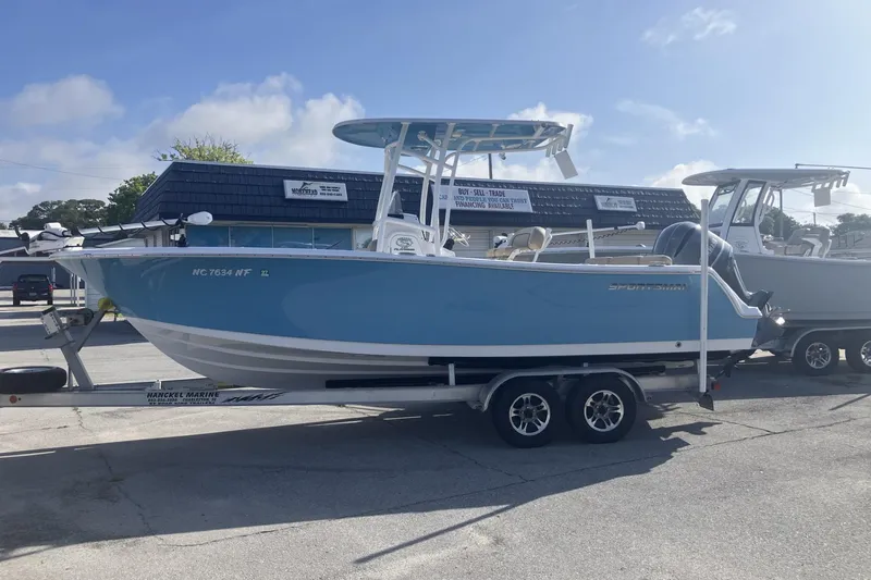 The Image of 2019 Sportsman Heritage 231 Center Console boat on trailer, parked outdoors. - 1