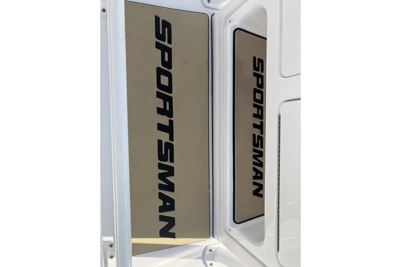 Slide: The Image of 2019 Sportsman Heritage 231 Center Console boat logo on white surface. - 14