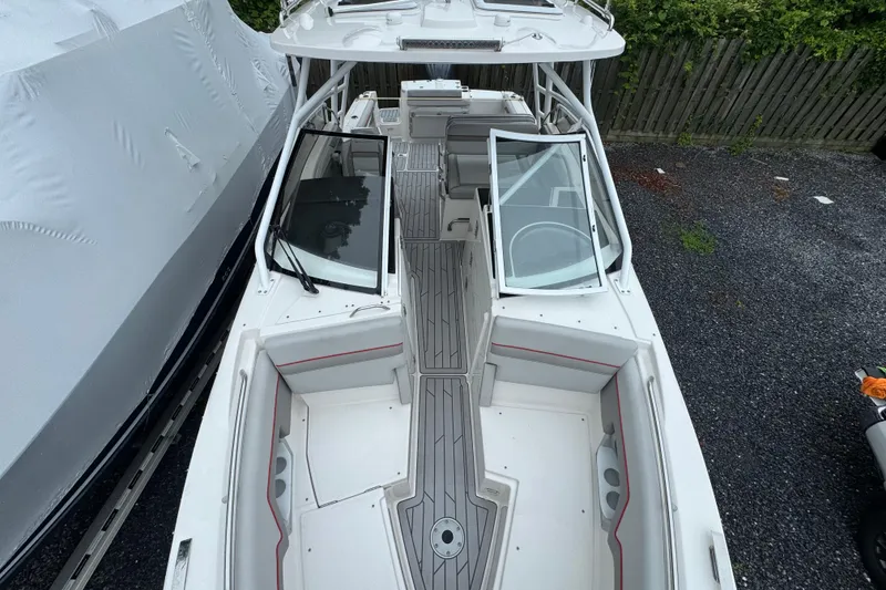 Slide: The Image of 2023 Solara S-250 DC boat with sleek design and spacious seating, docked outdoors. - 7