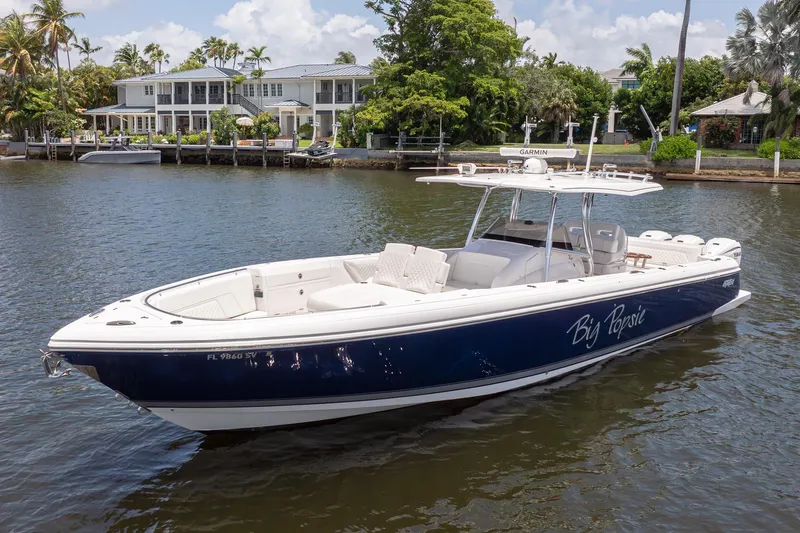 The Image of 2021 Intrepid 400 Center Console boat on calm water near luxury waterfront homes. - 0