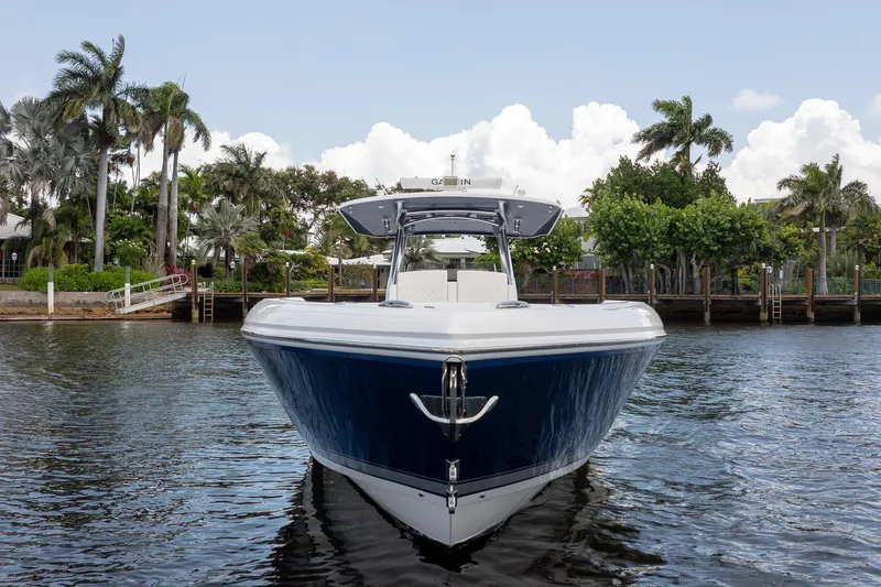 Slide: The Image of 2021 Intrepid 400 Center Console boat on water, surrounded by lush palm trees. - 2