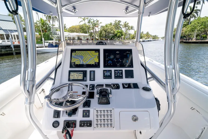 Slide: The Image of Intrepid 400 Center Console 2021 boat dashboard with navigation screens and controls on a sunny day. - 23