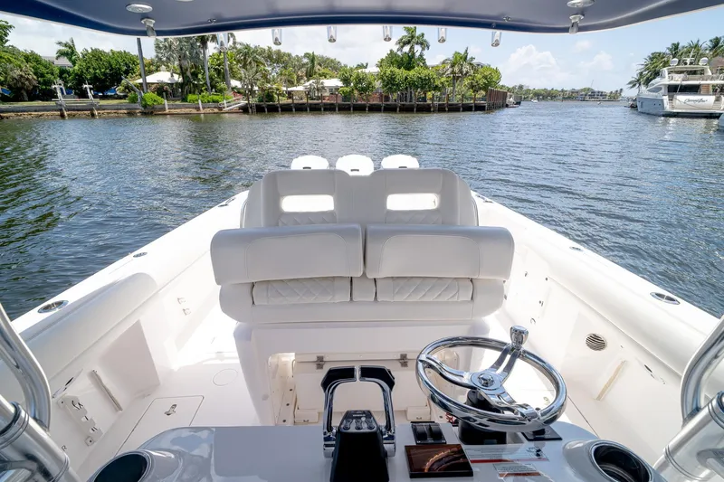 Slide: The Image of 2021 Intrepid 400 Center Console boat interior with steering wheel, white seating, and water view. - 26