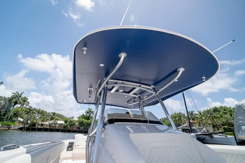 Slide: The Image of 2021 Intrepid 400 Center Console boat with sleek design and blue canopy. - 27
