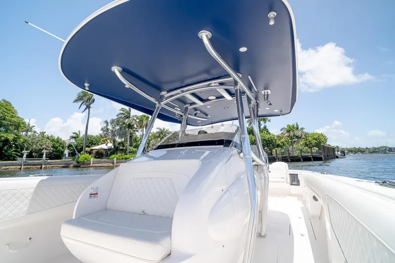 Slide: The Image of 2021 Intrepid 400 Center Console boat with sleek design, blue canopy, and waterfront view. - 31