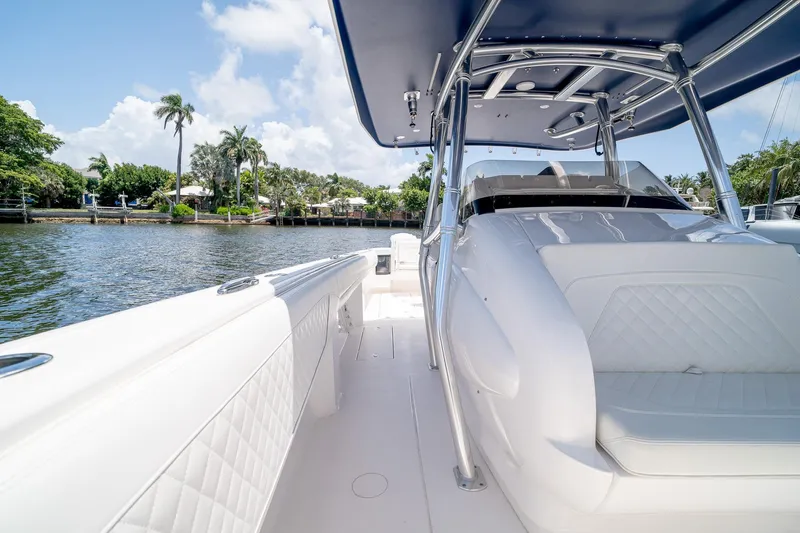 Slide: The Image of 2021 Intrepid 400 Center Console boat on calm water, featuring sleek white seating and canopy. - 32